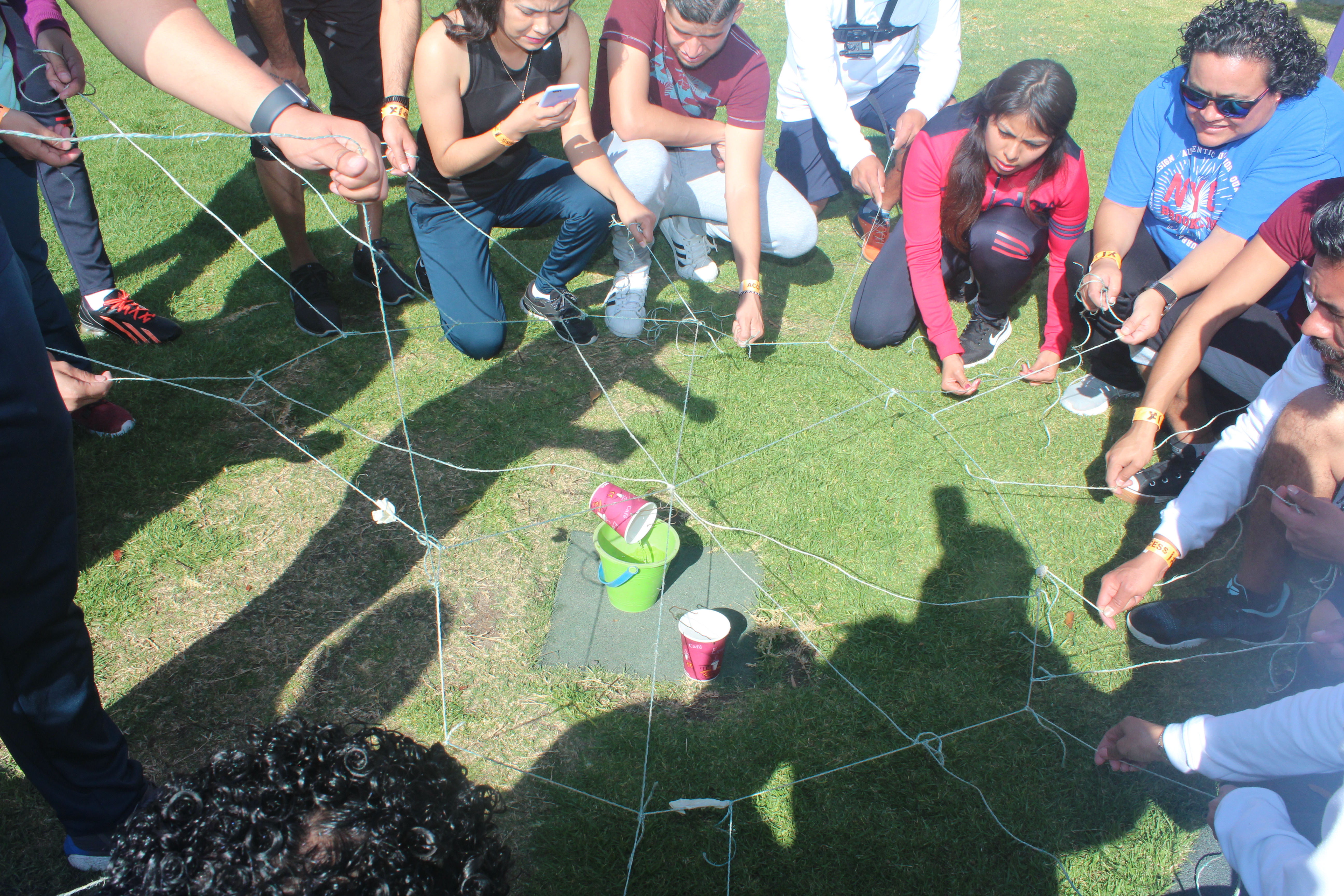 Grupo de alumnos resolviendo un desafío físico cooperativo en equipo